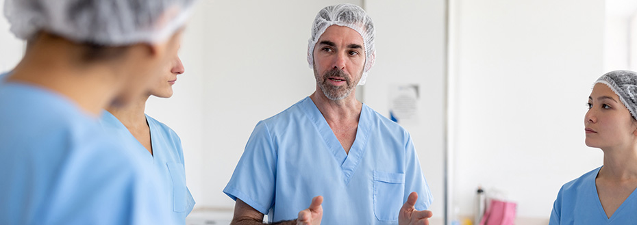 A surgeon talks to his team in a hospital operating room before a surgery.