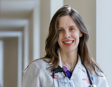  OHSU cardiologist Abigail Khan, M.D., M.S.C.E., smiles in a hallway at OHSU.