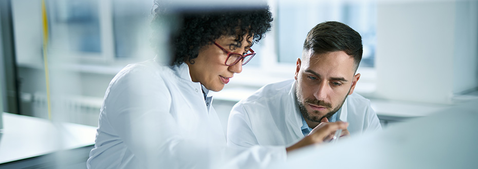 Two doctors in white lab coats work on research in a laboratory