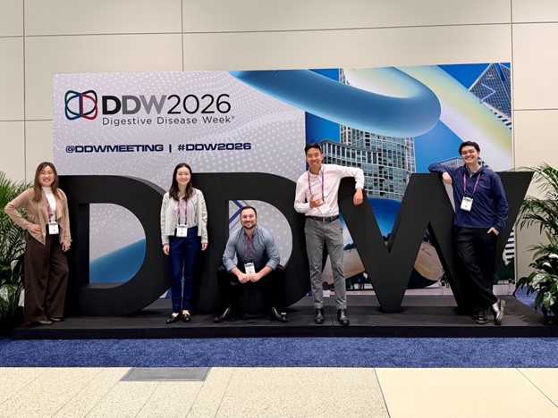 A group of fellows pose with the letters DDW at a conference.