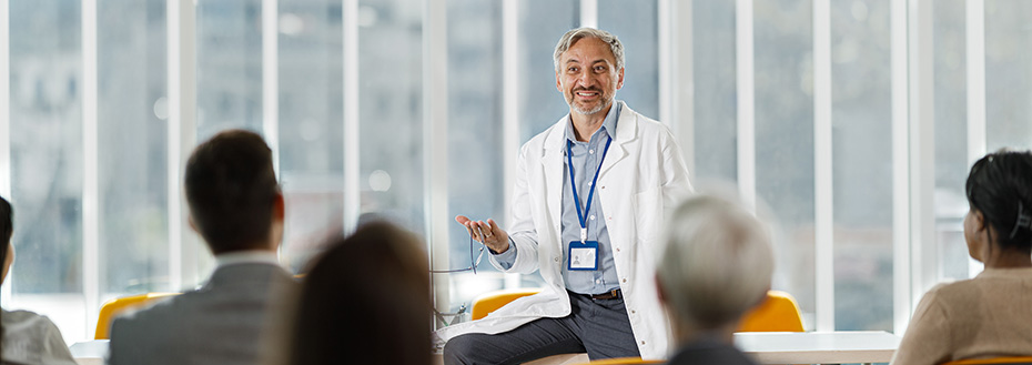 A male doctor gives a presentation in front of medical professionals.