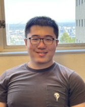A man smiling in front of a window.