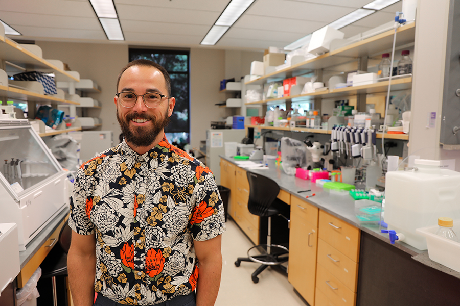 A man stands in a research laboratory smiling.