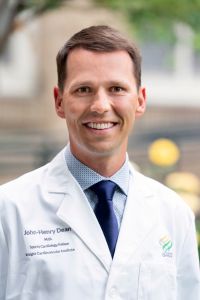 A professional headshot of Dr. John-Henry Dean.