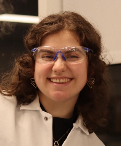 Person in lab coat, smiling