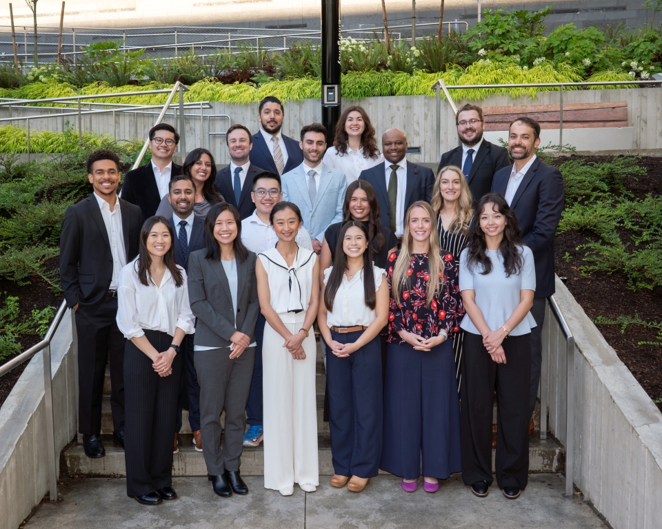 A group of 20 people dressed professional smile and post together for the camera.