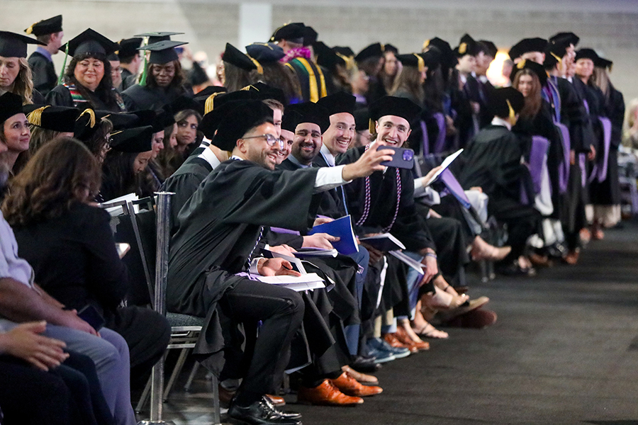 Students in their black cap and gowns at graduation.