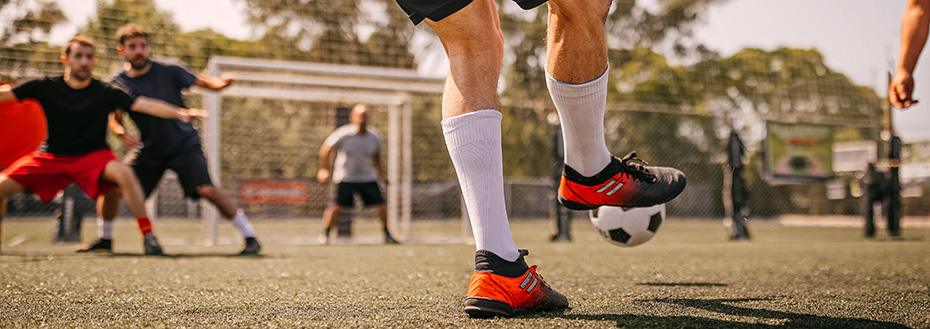 A soccer player kicks a soccer ball toward the goal during a recreational game.