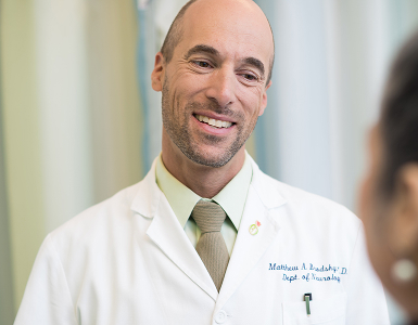 OHSU neurologist Matthew Brodsky, M.D., talks to a patient whose face we can't see.