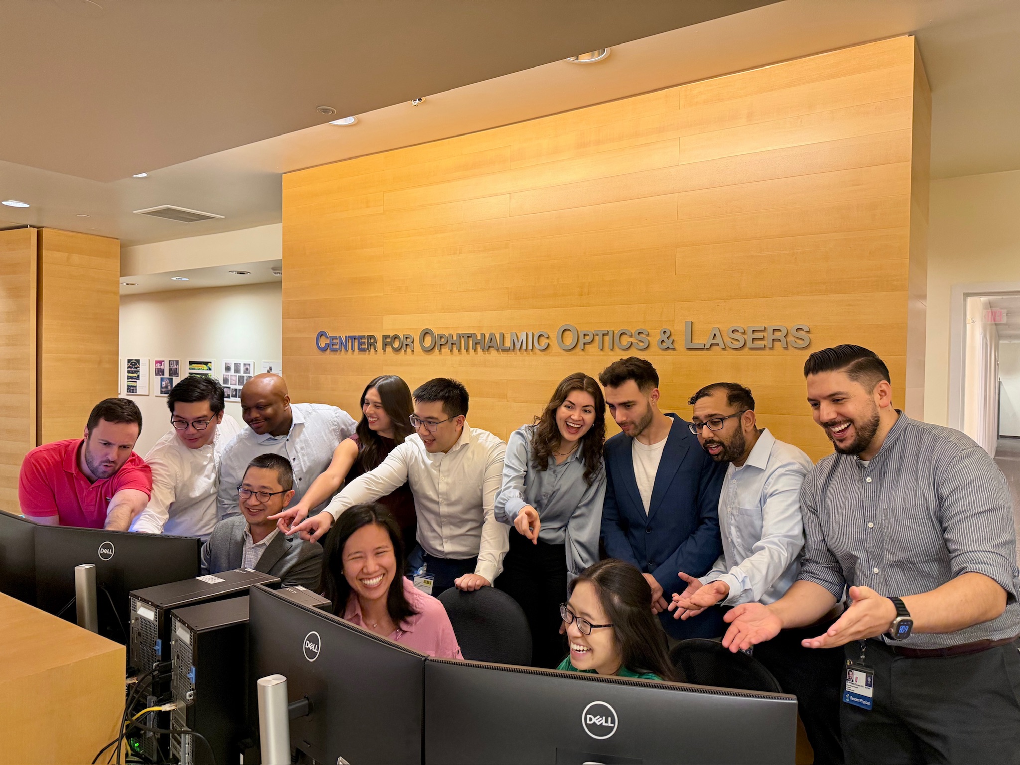 A group of people pretend confusion and chaos in front of computers.