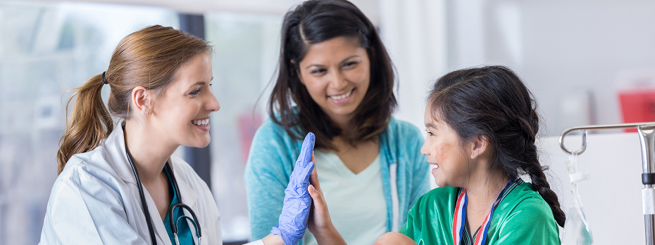 Young emergency room doctor gives a young patient a high five as her mom looks on.