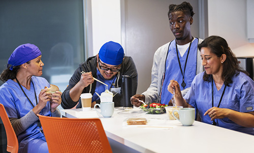 Several healthcare workers eating a meal together.