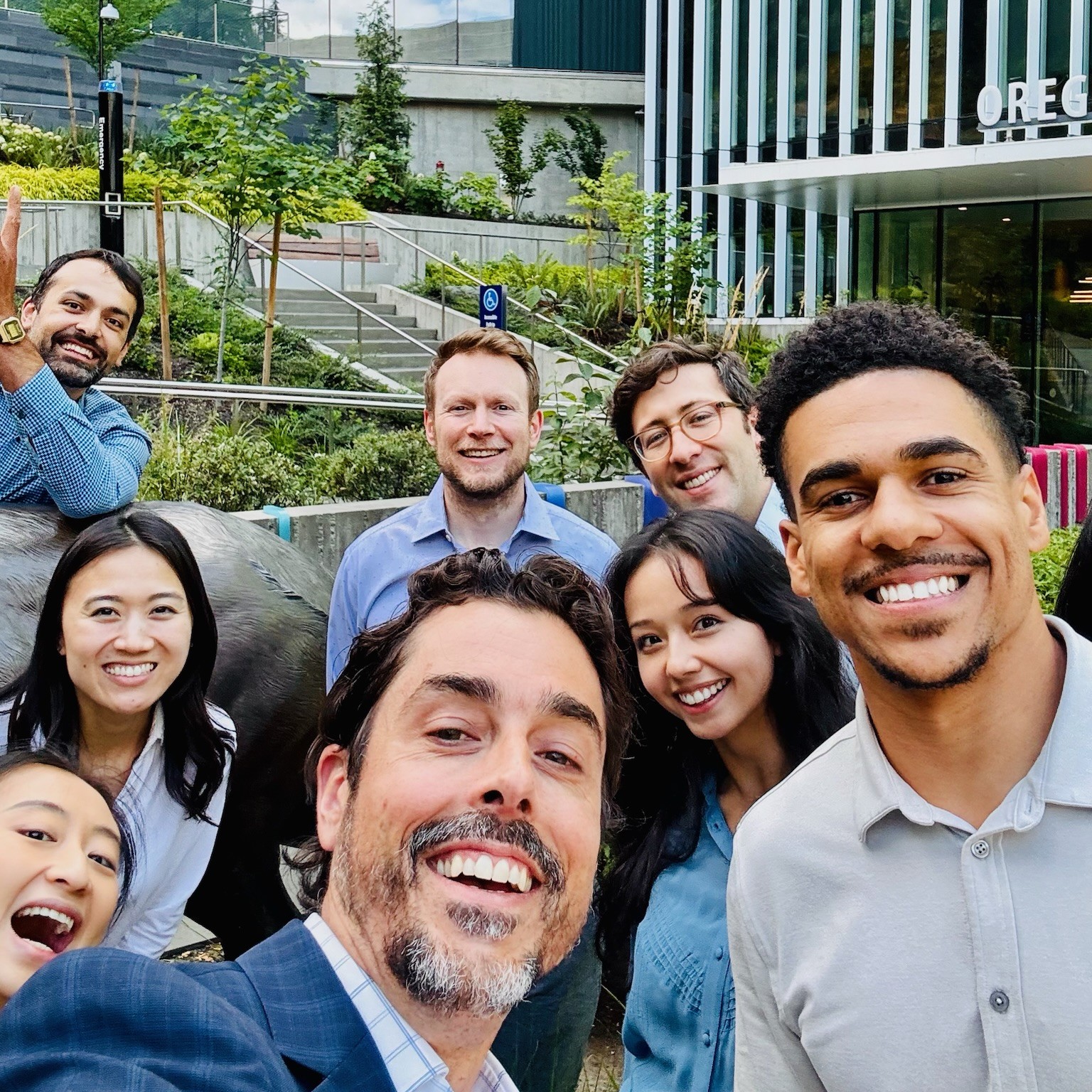 A group of residents and faculty pose for a selfie in front of the elk statue.