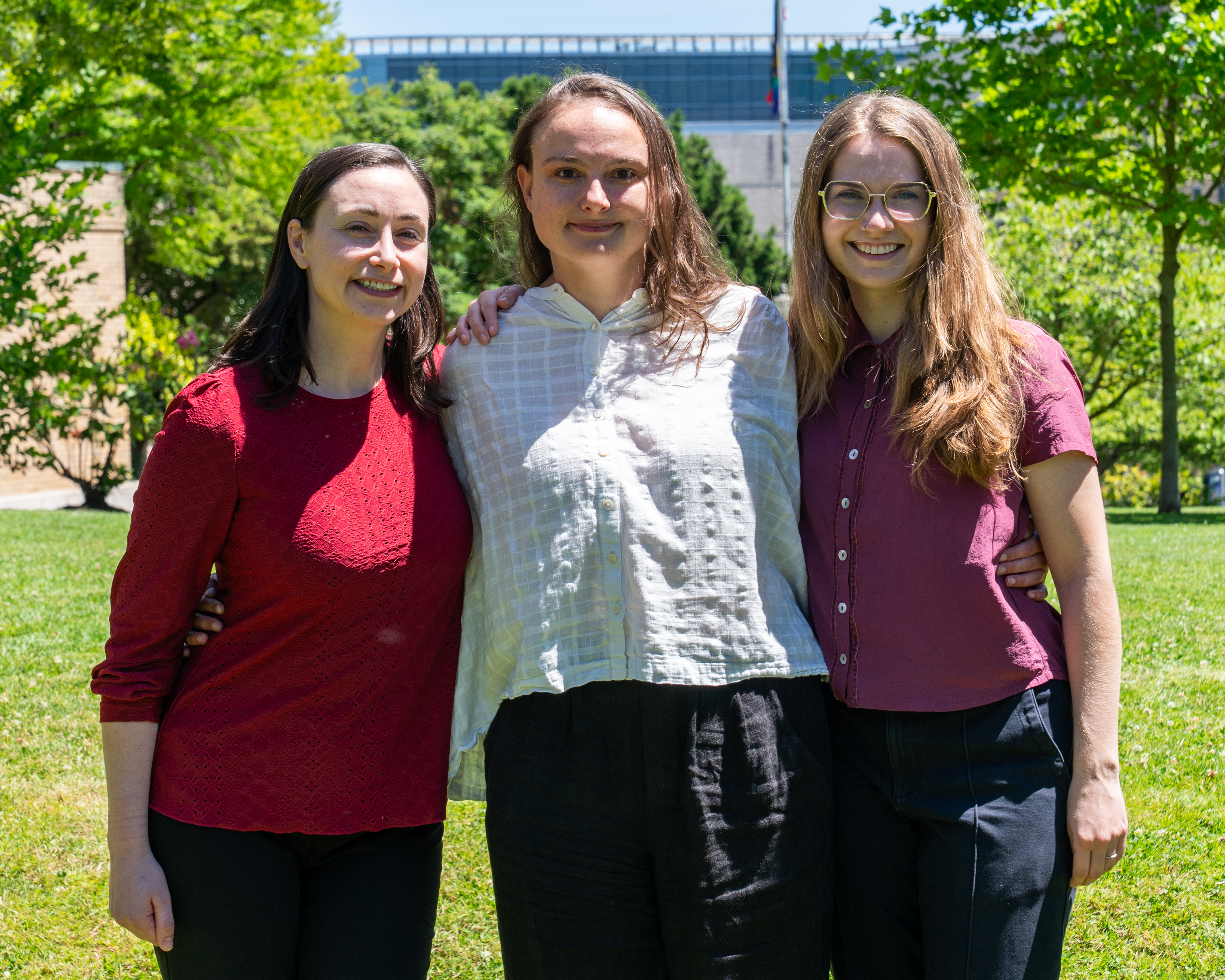 Group photo of three women in professional clothes smiling at the camera