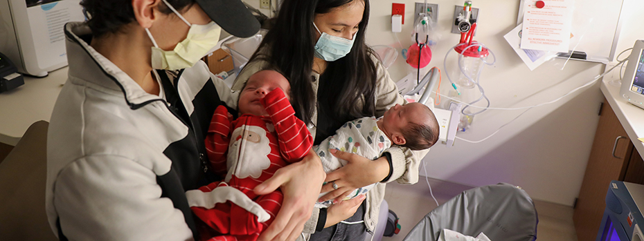 A couple hold their infant twins.