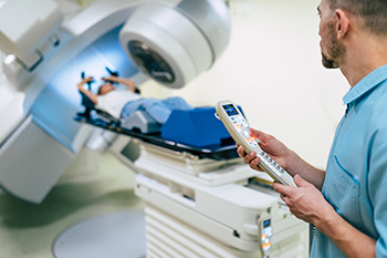 Radiation therapist monitors a patient during radiation treatment.