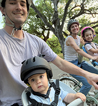 Photo of Alex Dahl riding bikes with his spouse and two kids