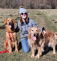 Arin Tyler posing with her two golden retrievers
