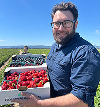 Brandon Nauss holding a crate of fresh-picked berries