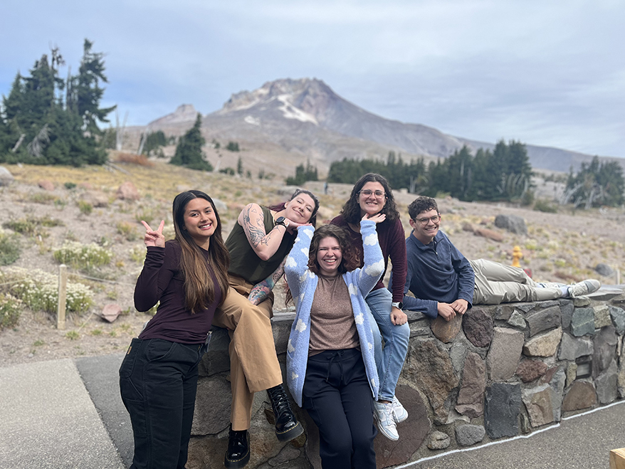 Group of 5 graduate students in happy poses with Mt Hood in the background
