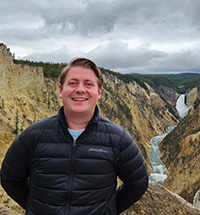 James Wells in front a canyon with a river