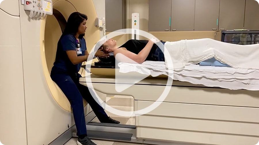 Screenshot from an explainer video showing a patient positioned on a simulation table with a radiation therapist.