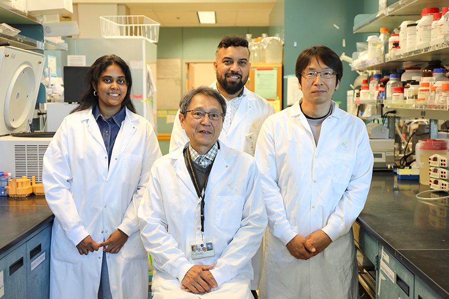 Four OHSU scientists in lab coats pose in their lab.