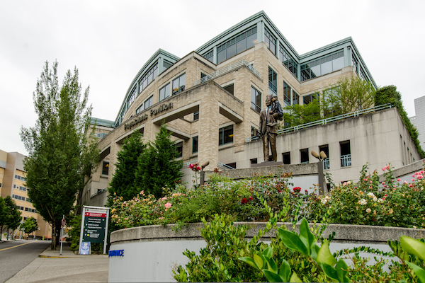 Physicians Pavilion brick building with greenery surrounding it.